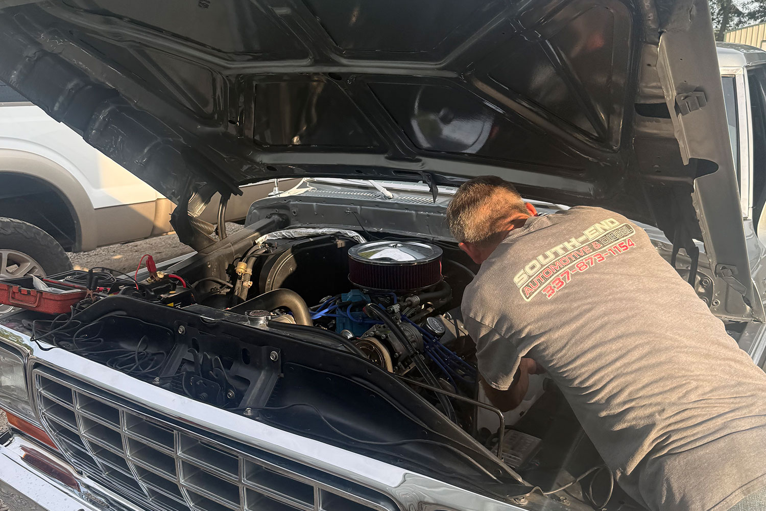 Technician running under-hood diagnostics on a customer vehicle